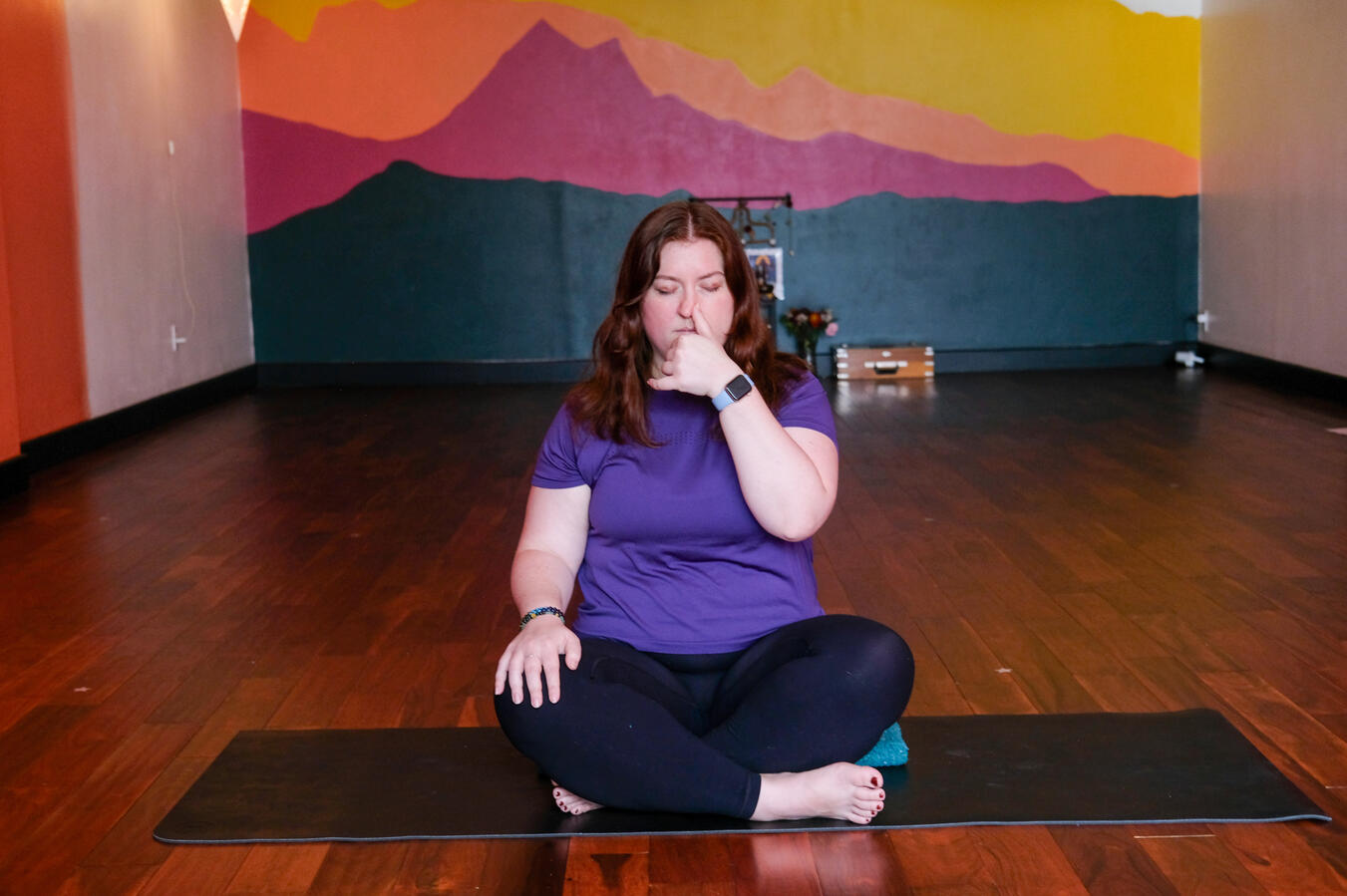 Steph meditating on a yoga mat