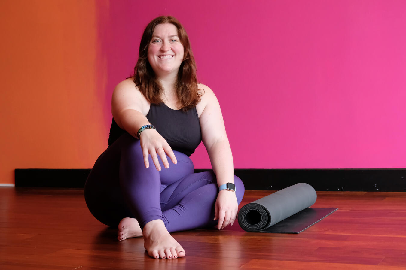 Steph smiling with a rolled up yoga mat